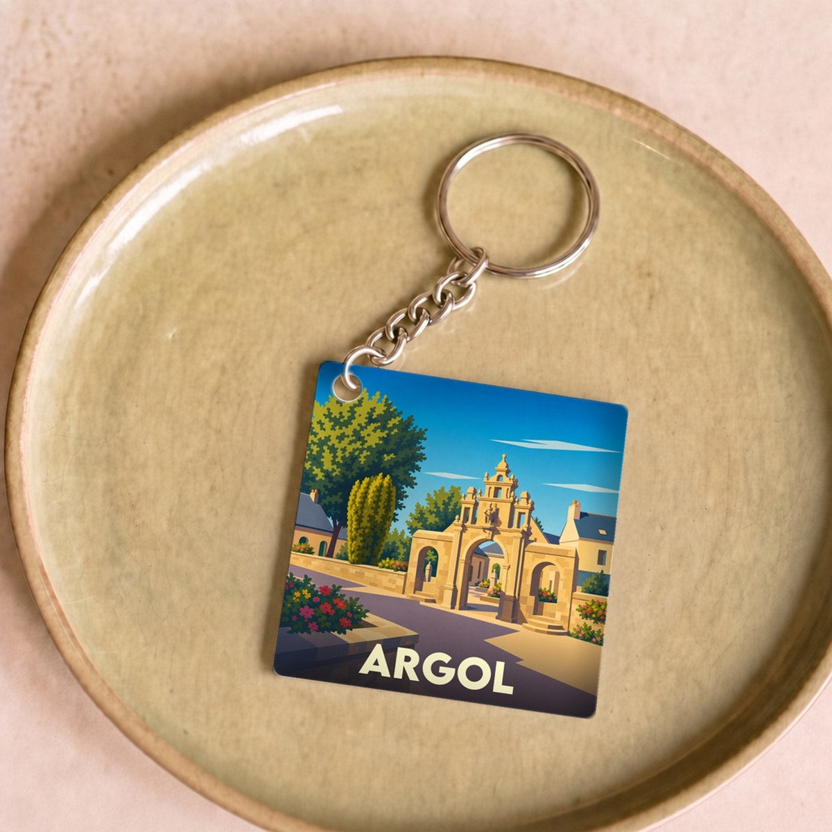 Porte-clés souvenir de la ville d'Argol avec une illustration stylisée de son enclos paroissial.