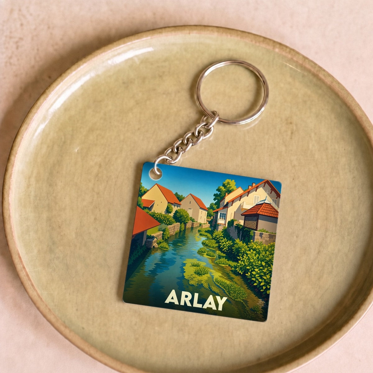 Porte-clés souvenir de la ville d'Arlay avec une illustration stylisée.