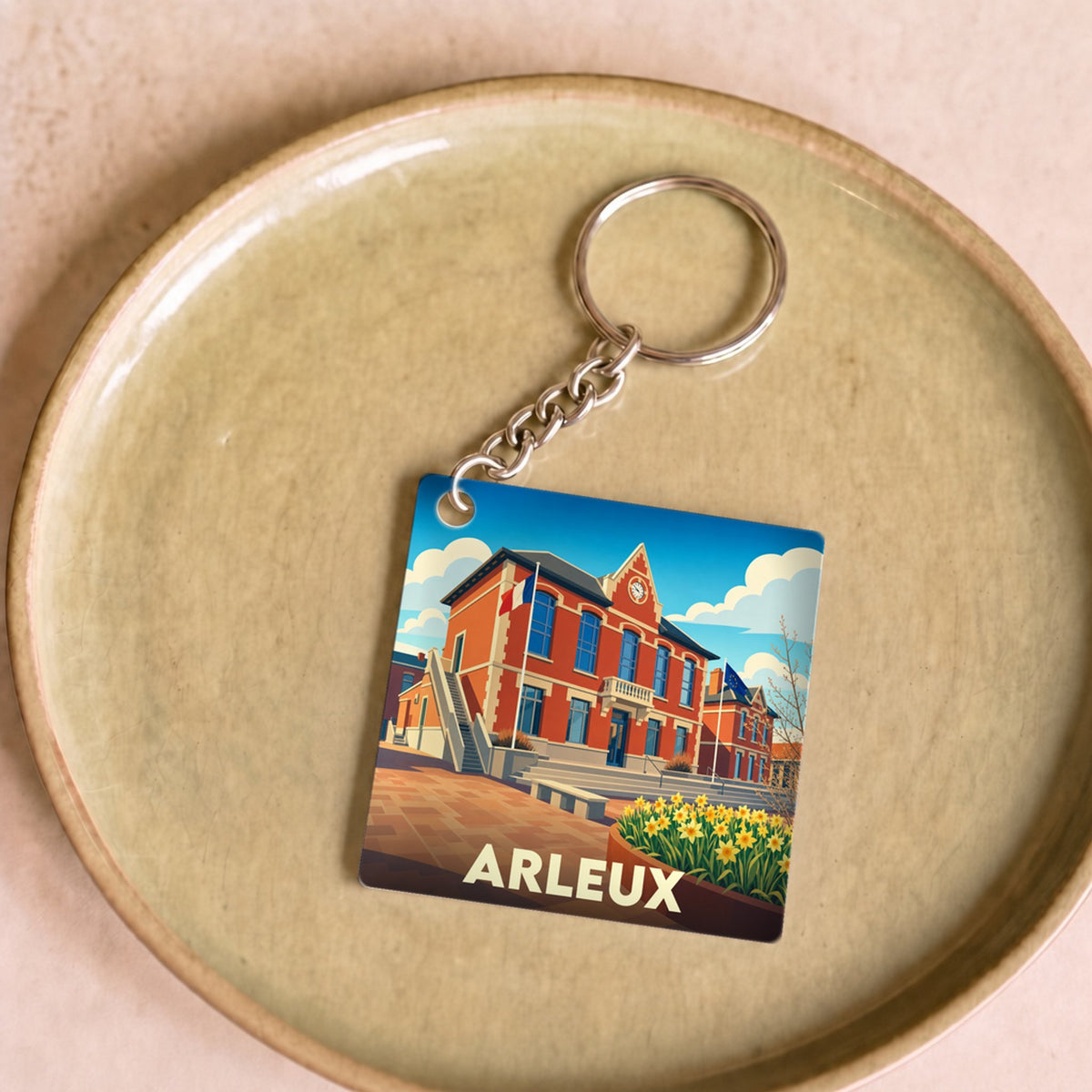 Porte-clés souvenir de la ville d'Arleux avec une illustration colorée et stylisée de son hôtel de ville.