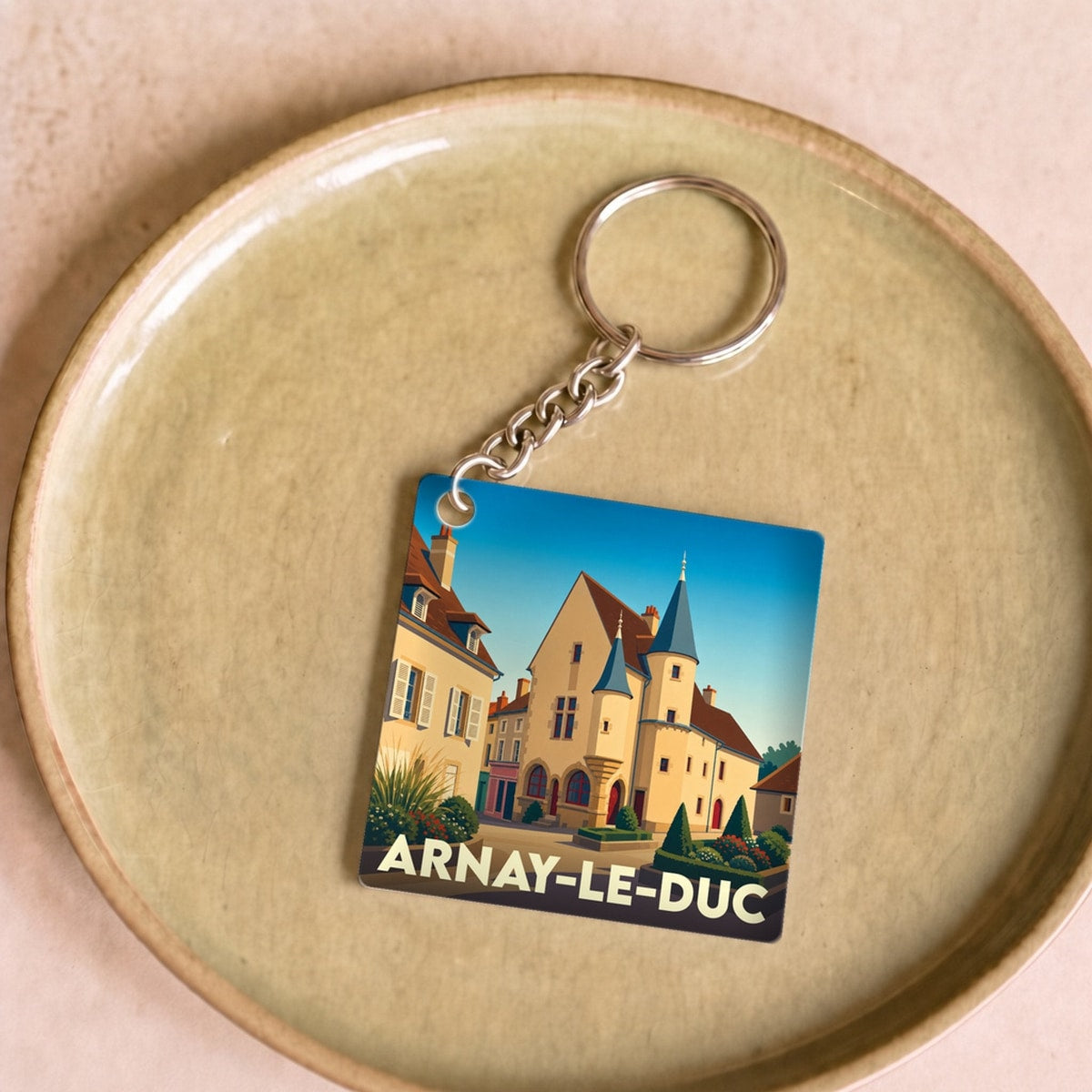 Porte-clés souvenir de la ville d'Arnay-le-Duc avec une illustration stylisée de son architecture.