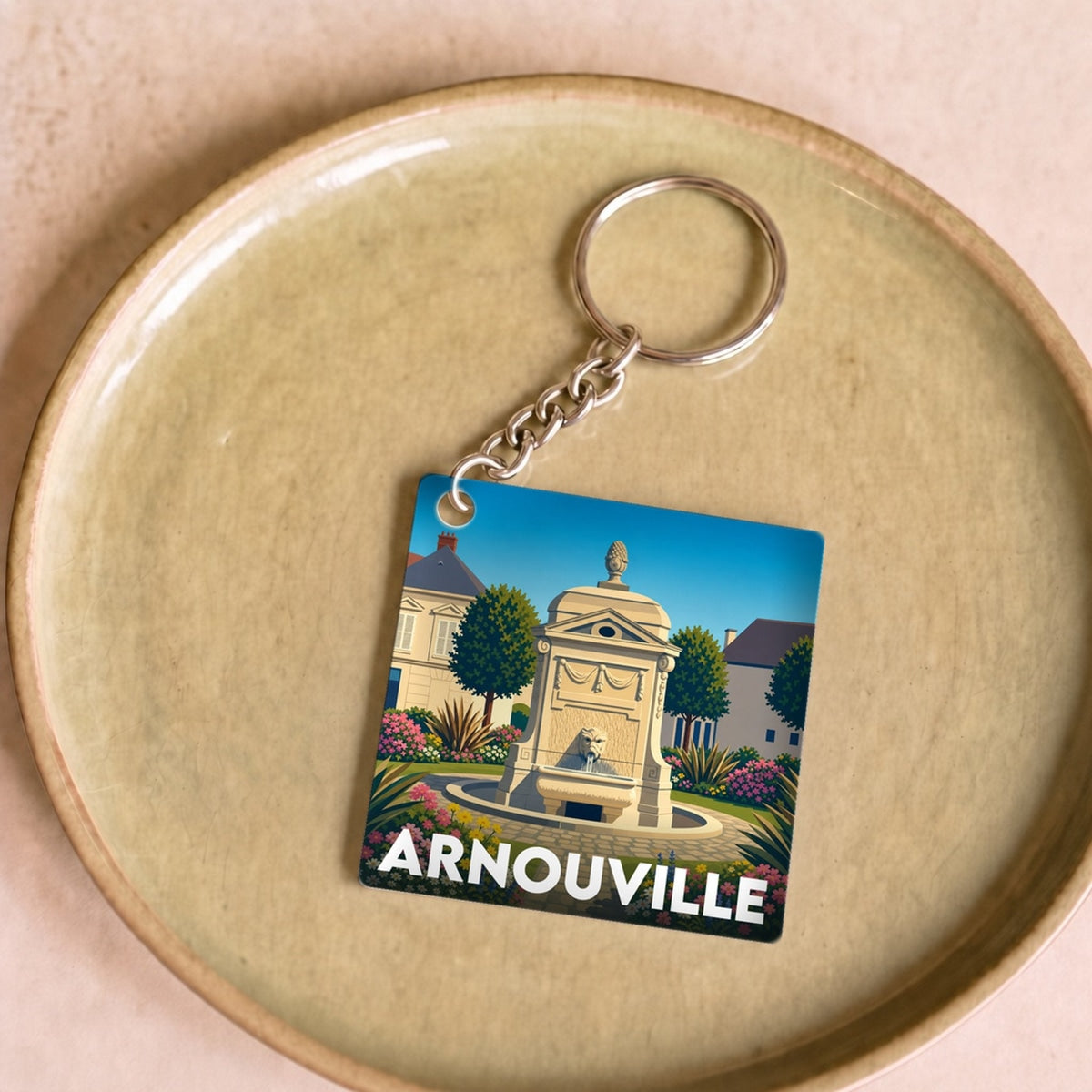 Porte-clés souvenir de la ville d'Arnouville avec une illustration stylisée.