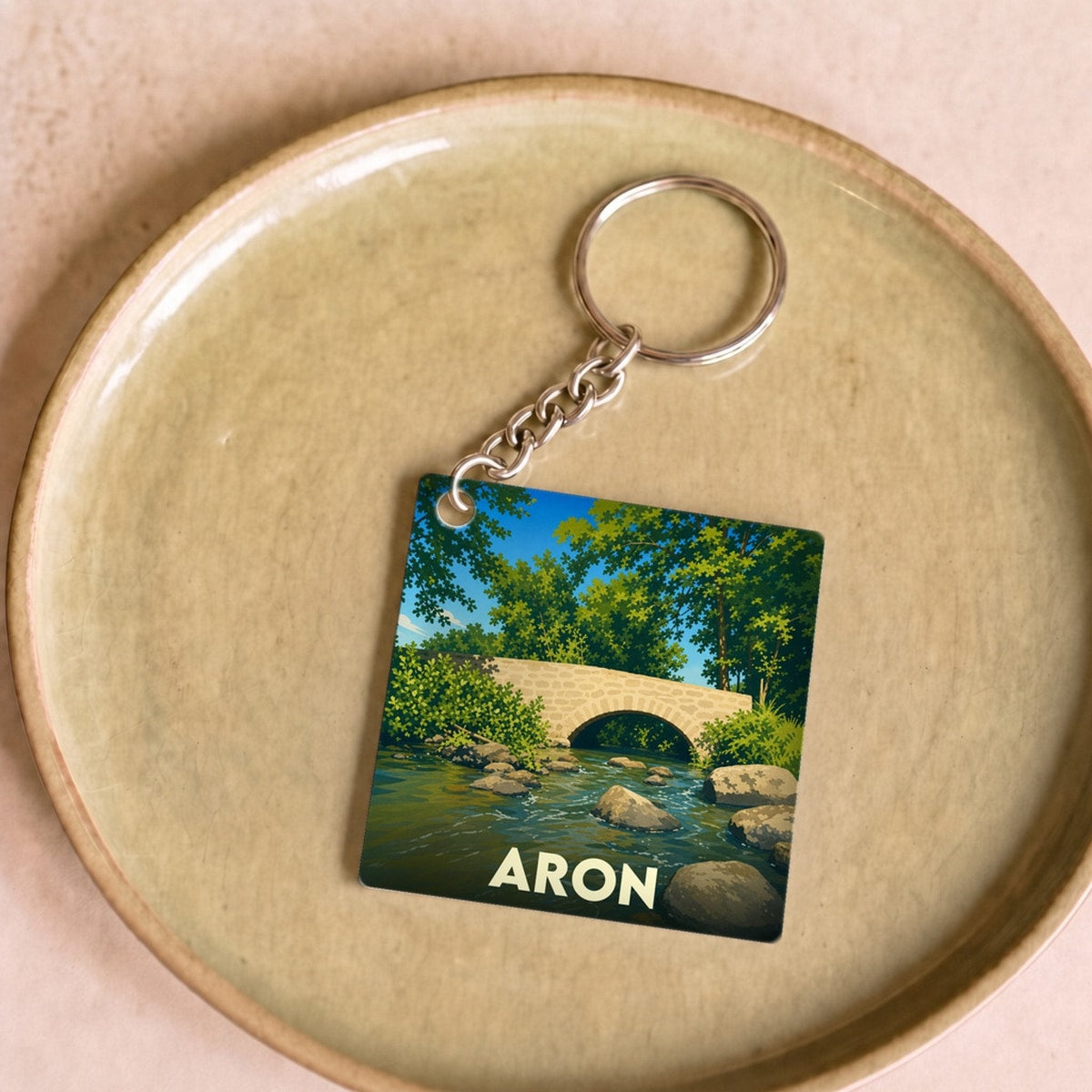 Porte-clés souvenir de la ville de Aron avec une illustration stylisée d'un pont en pierre.