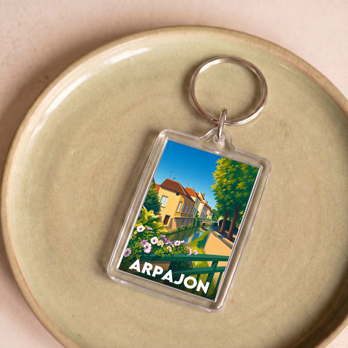 Porte-clés souvenir de la ville d'Arpajon avec une illustration stylisée.