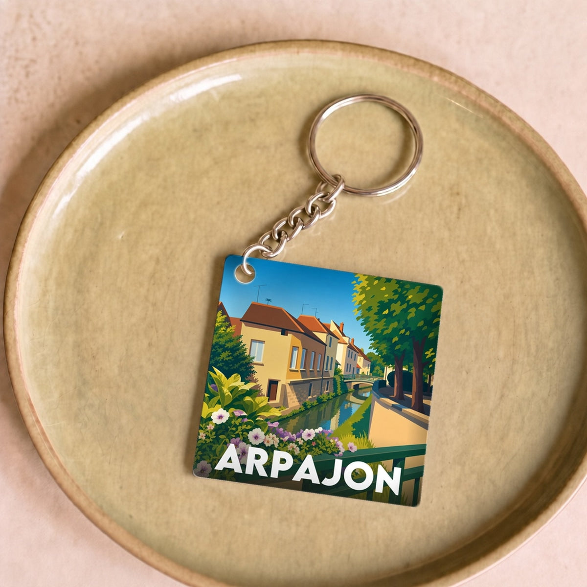 Porte-clés souvenir de la ville d'Arpajon avec une illustration stylisée.