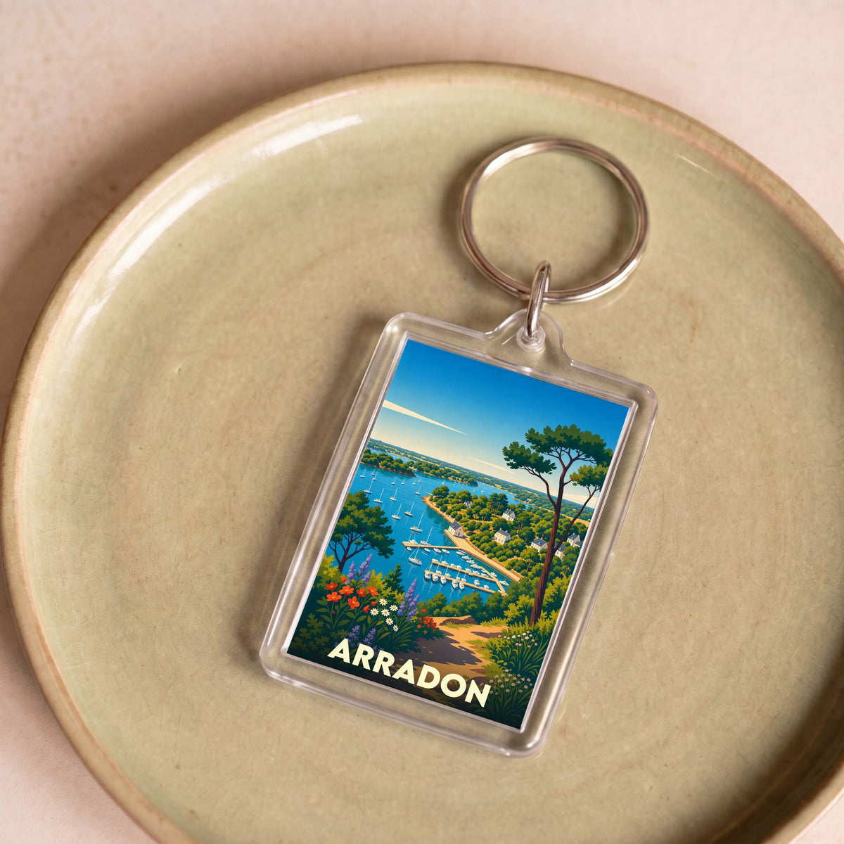 Porte-clés souvenir de la ville d'Arradon avec une illustration stylisée de son littoral et de son port.