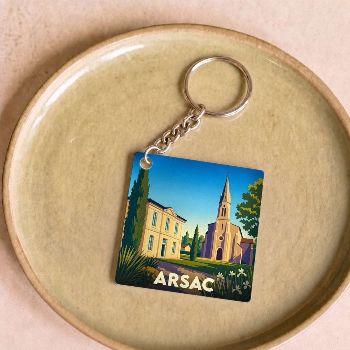 Porte-clés souvenir de la ville d'Arsac avec une illustration stylisée.
