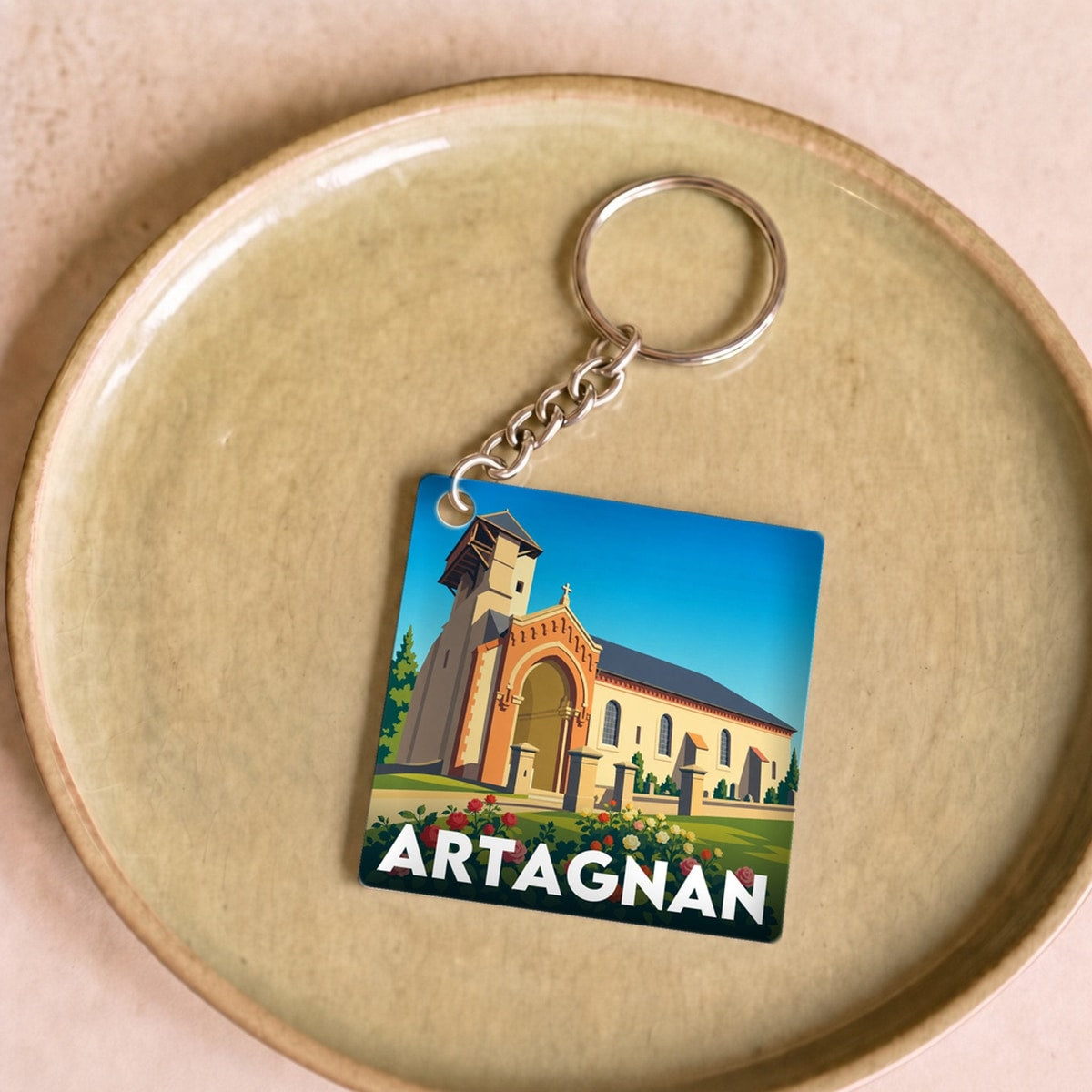 Porte-clés souvenir de la ville d'Artagnan avec une illustration stylisée de son église.