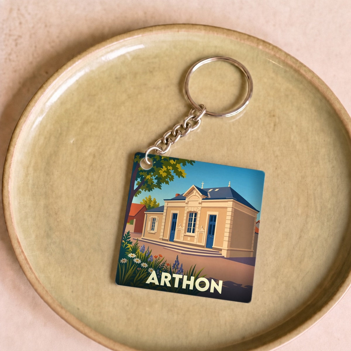 Porte-clés souvenir de la ville d'Arthon avec une illustration stylisée de sa mairie.