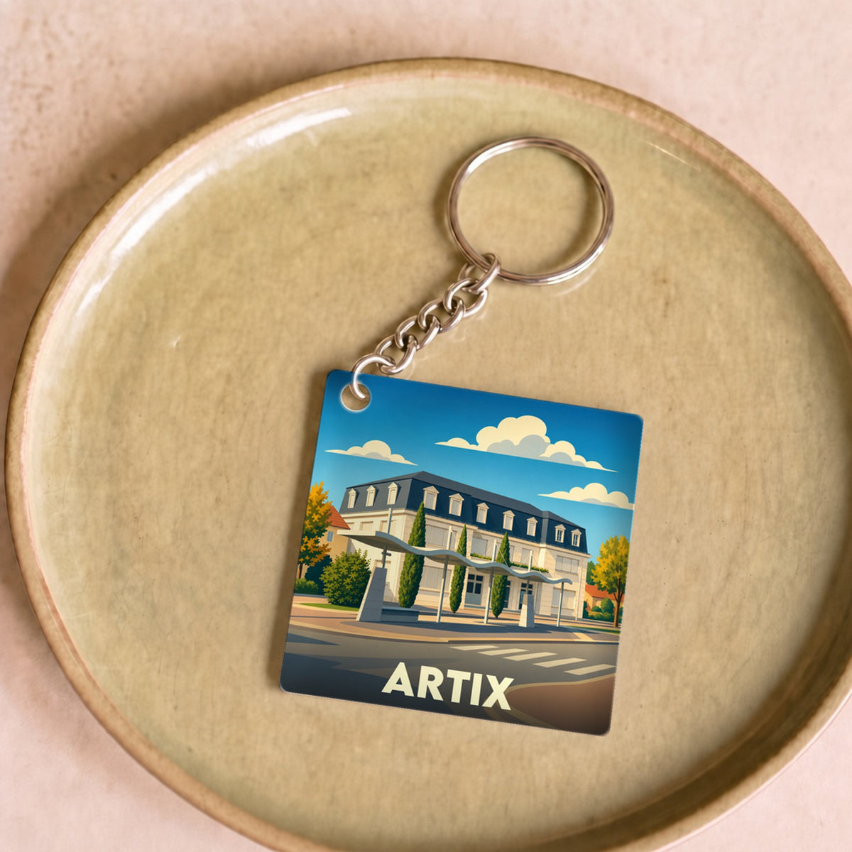 Porte-clés souvenir de la ville d'Artix avec une illustration stylisée de sa mairie.