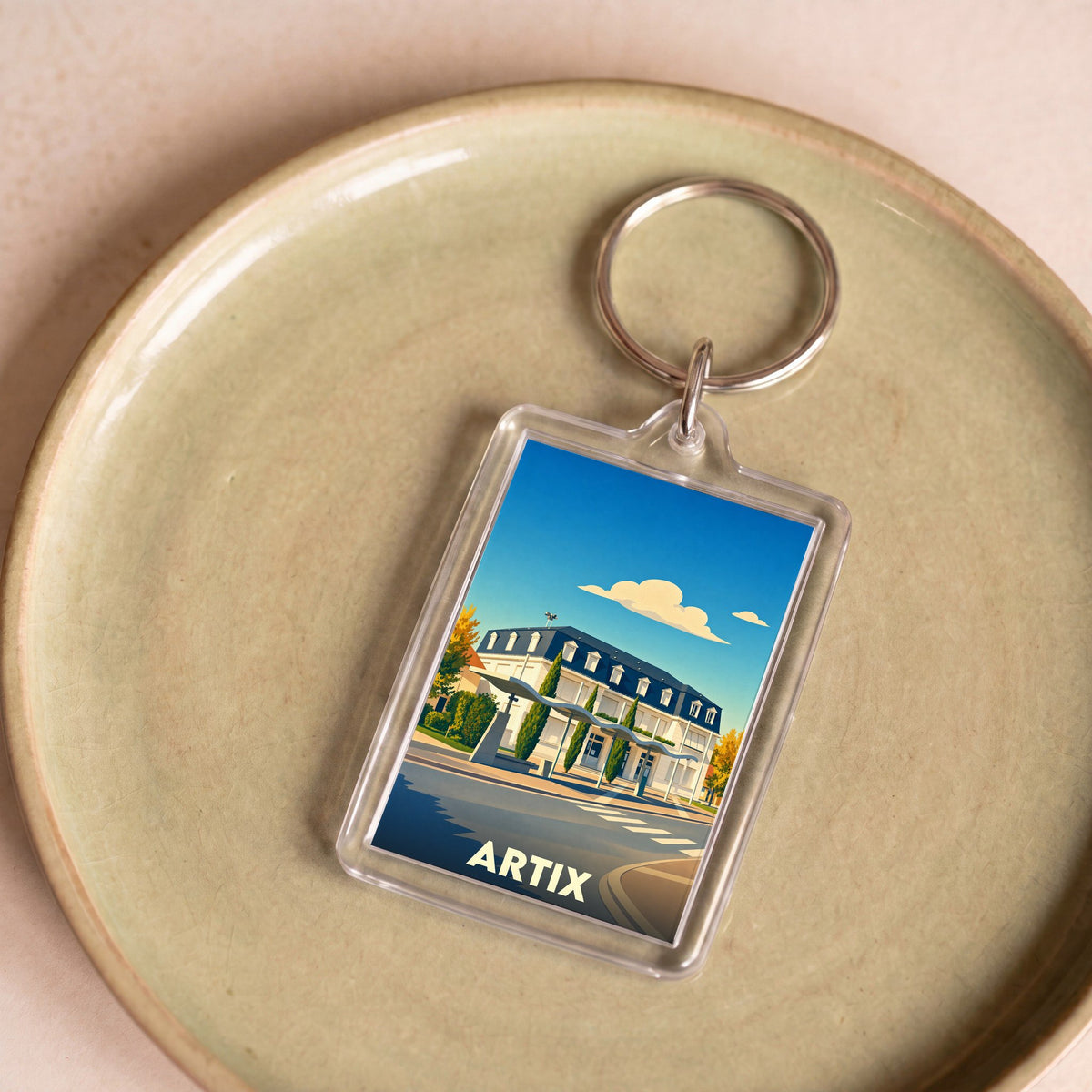 Porte-clés souvenir de la ville d'Artix avec une illustration stylisée de sa mairie.