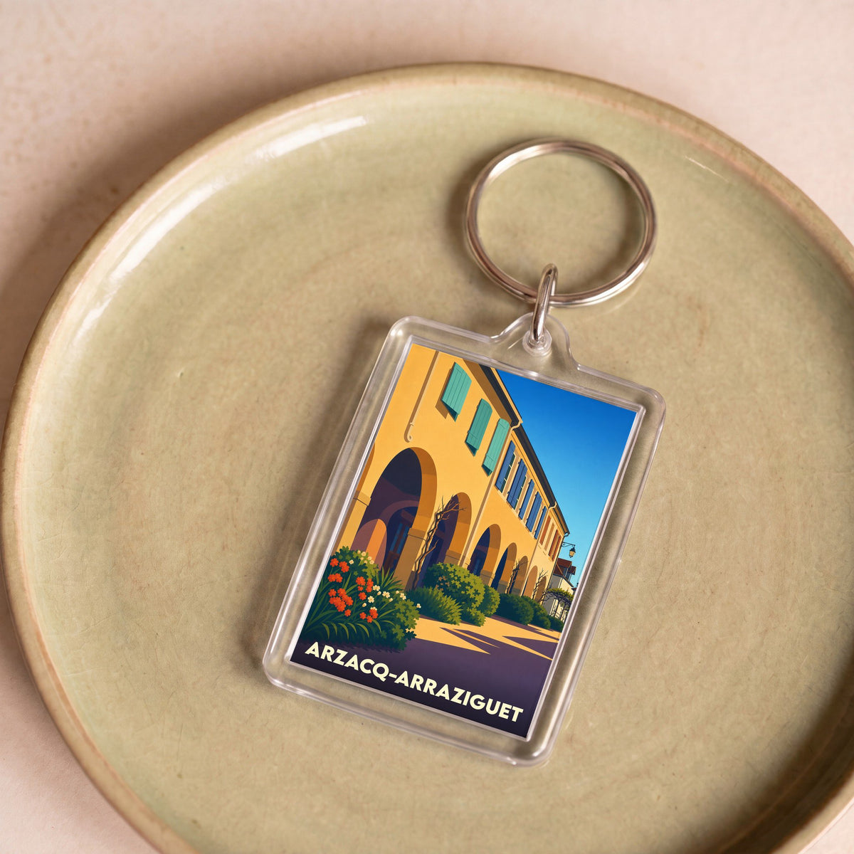 Porte-clés souvenir de la ville d'Arzacq-Arraziguet avec une illustration stylisée.