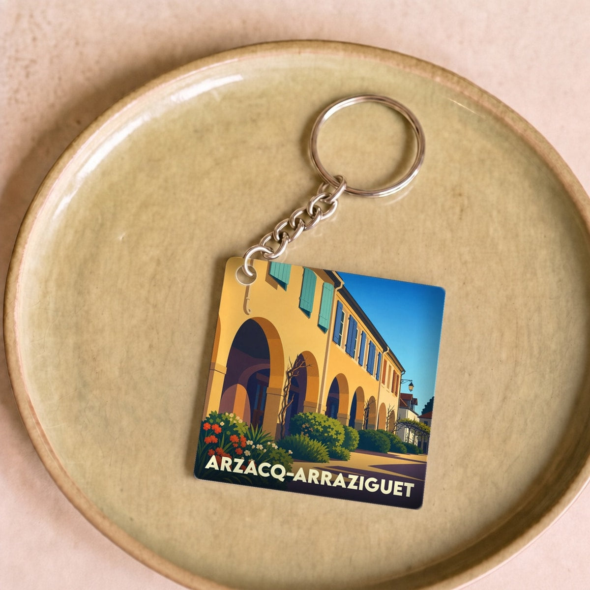 Porte-clés souvenir de la ville d'Arzacq-Arraziguet avec une illustration stylisée.