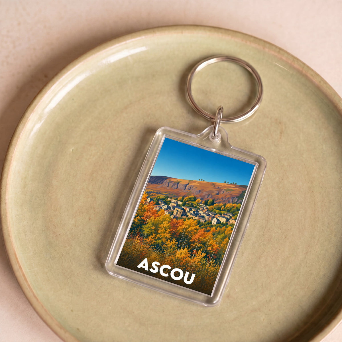 Porte-clés souvenir de la ville d'Ascou avec une illustration stylisée.