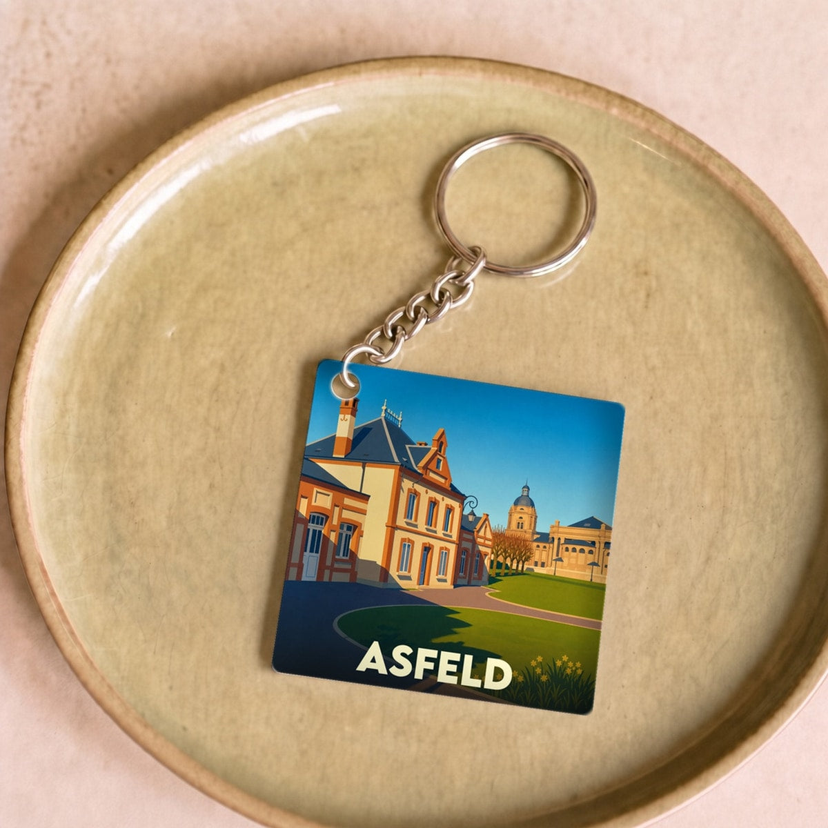 Porte-clés souvenir de la ville d'Asfeld avec une illustration stylisée.