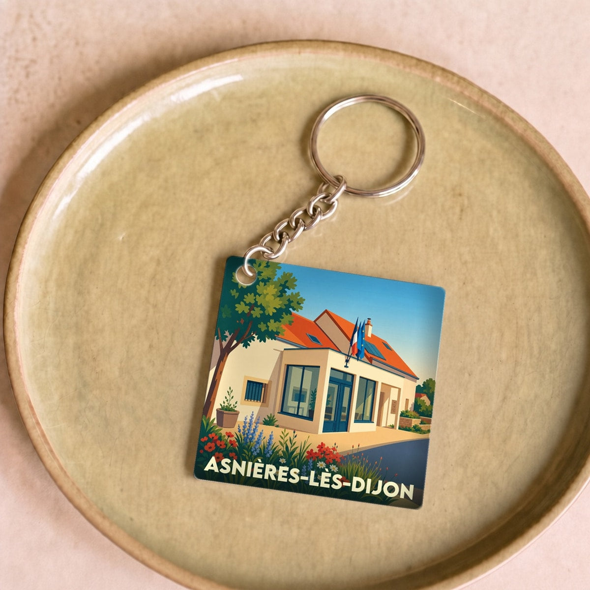 Porte-clés souvenir de la ville d'Asnières-lès-Dijon avec une illustration stylisée.