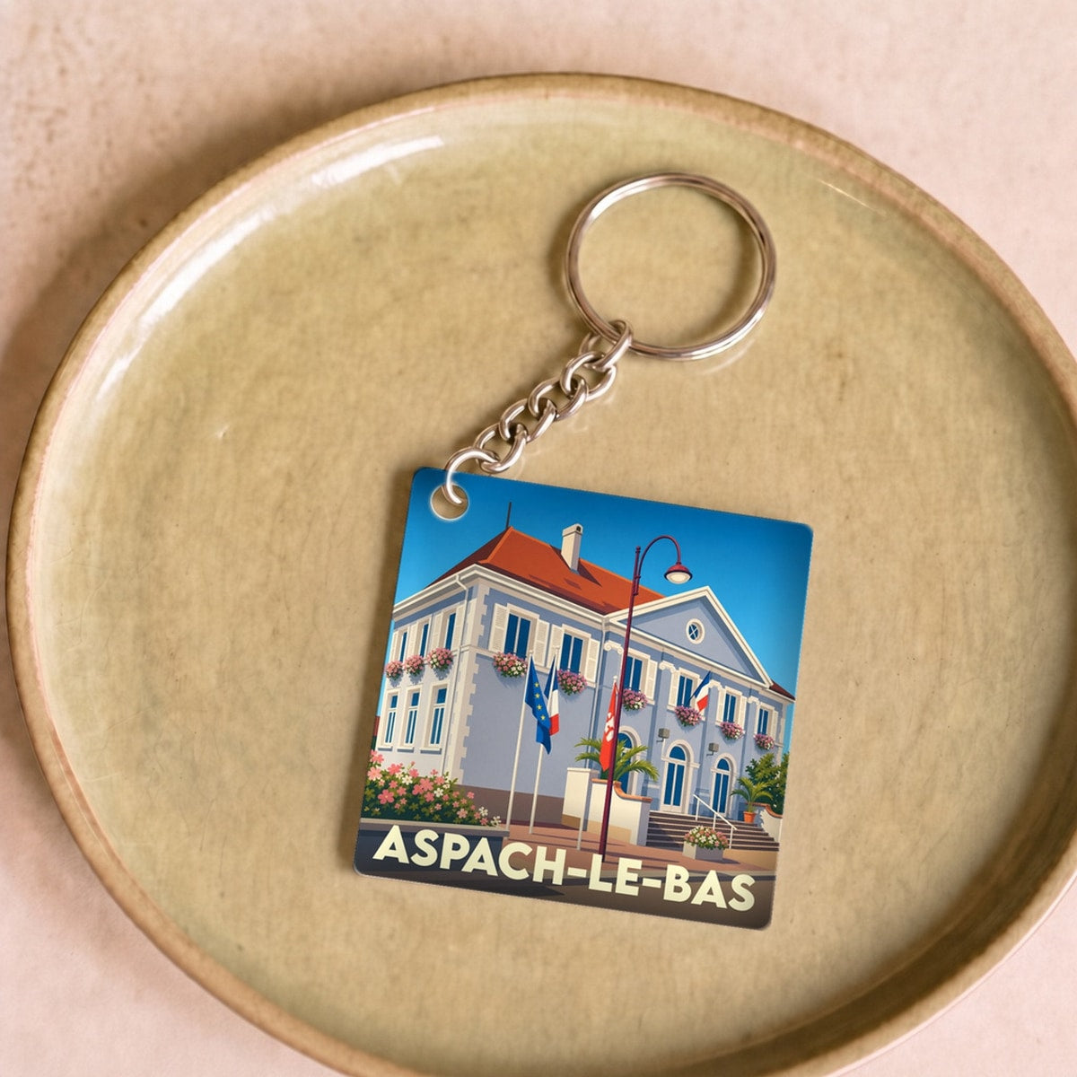 Porte-clés souvenir de la ville d'Aspach-le-Bas avec une illustration stylisée de sa mairie.