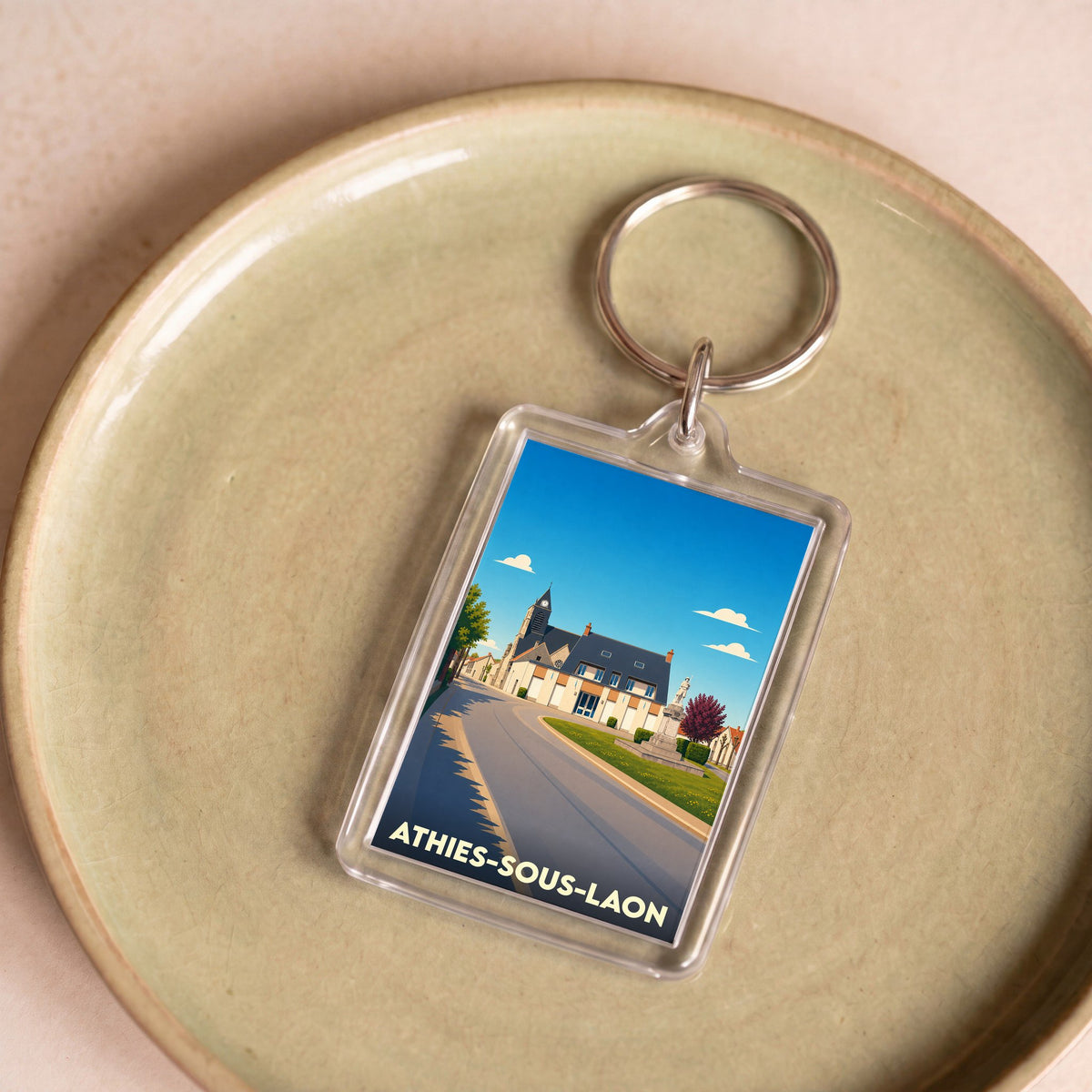 Porte-clés souvenir de la ville de Athies-sous-Laon avec une illustration stylisée.