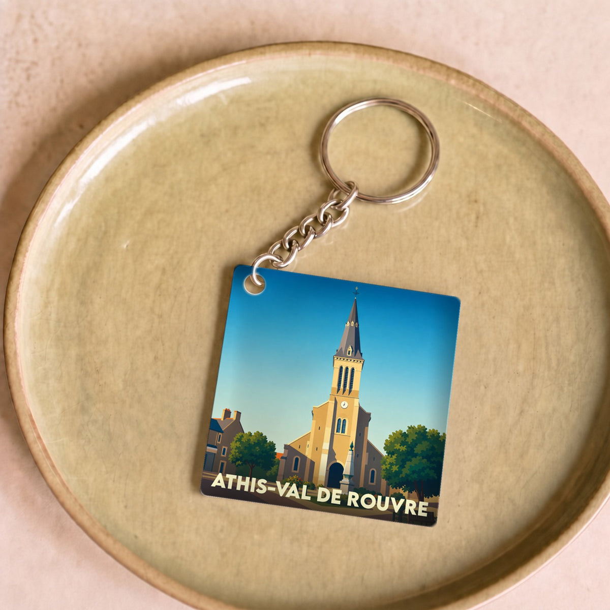 Porte-clés souvenir de la ville de Athis-Val de Rouvre avec une illustration stylisée de son église.