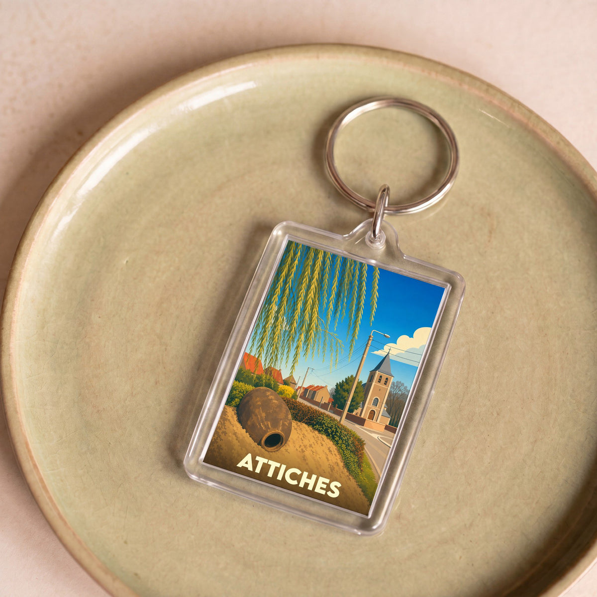 Porte-clés souvenir de la ville d'Attiches avec une illustration stylisée.