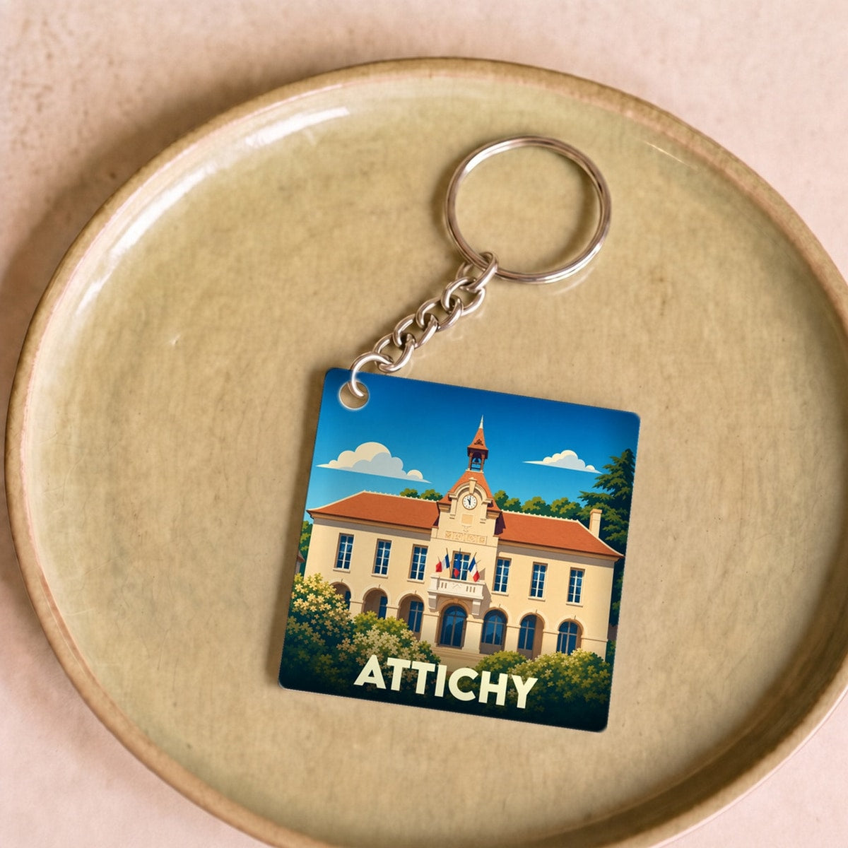 Porte-clés souvenir de la ville de Attichy avec une illustration stylisée de sa mairie.