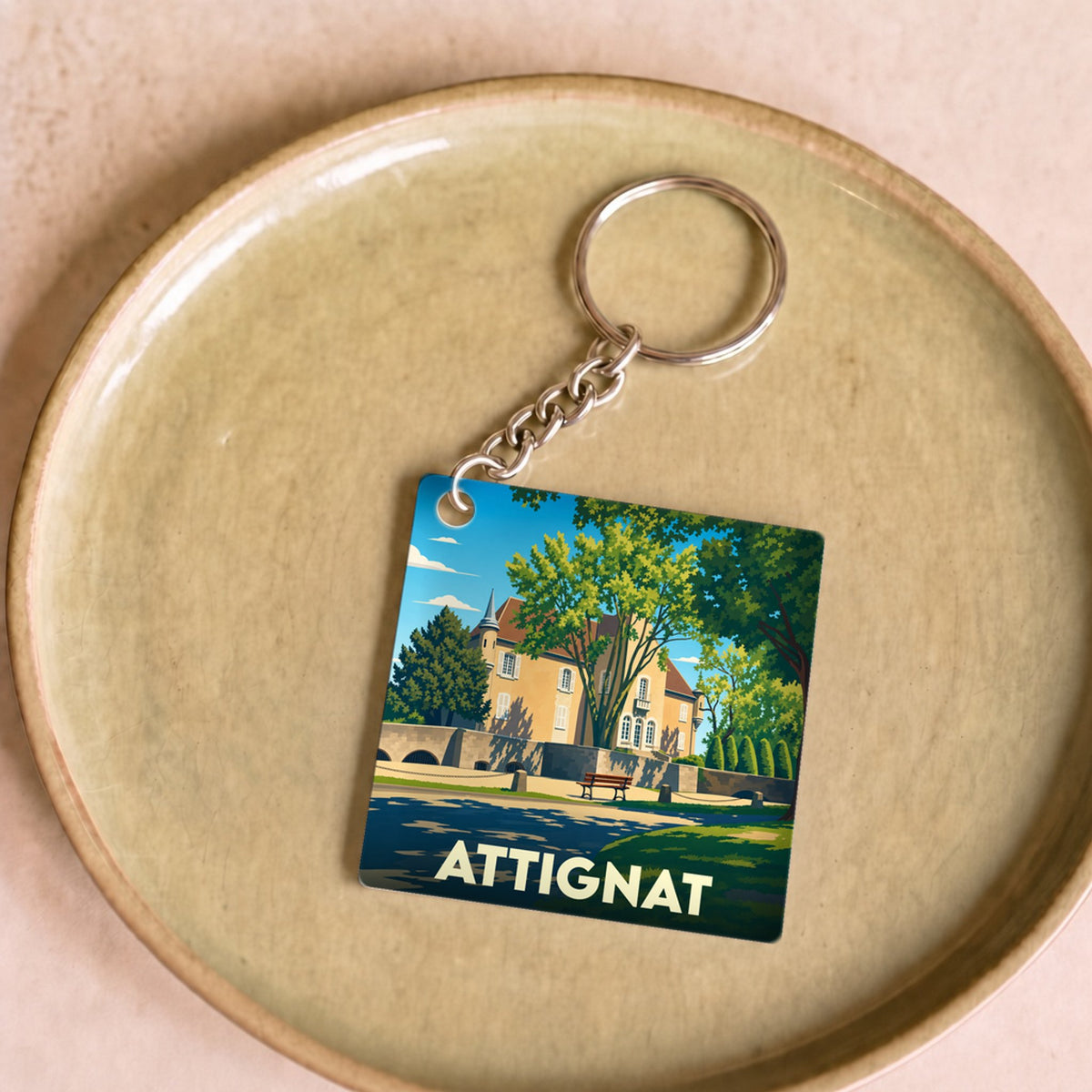 Porte-clés souvenir de la ville d'Attignat avec une illustration stylisée d'un château.