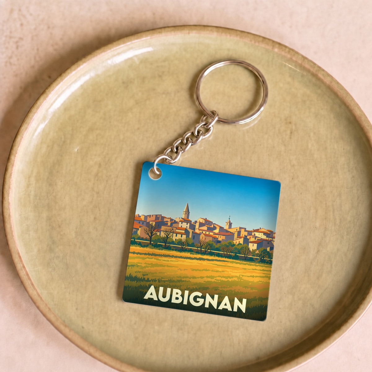 Porte-clés souvenir de la ville de Aubignan avec une illustration stylisée.