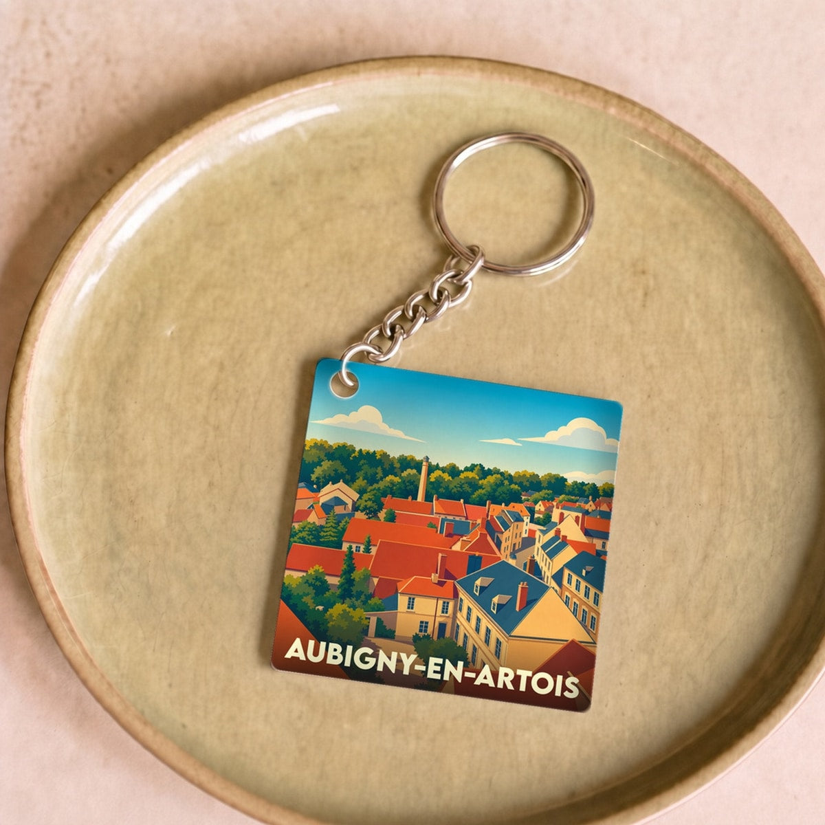 Porte-clés souvenir de la ville de Aubigny-en-Artois avec une illustration stylisée de ses toits.