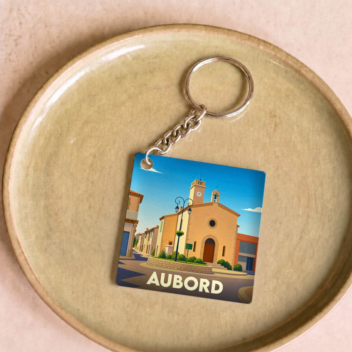 Porte-clés souvenir de la ville de Aubord avec une illustration stylisée de son église.