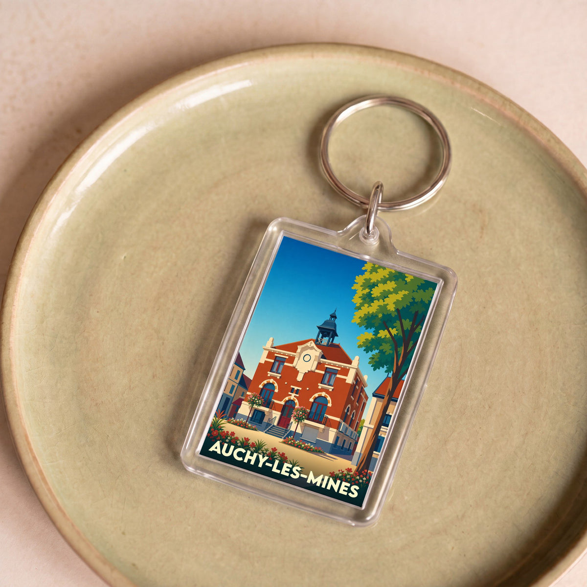 Porte-clés souvenir de la ville d'Auchy-les-Mines avec une illustration stylisée de son hôtel de ville.
