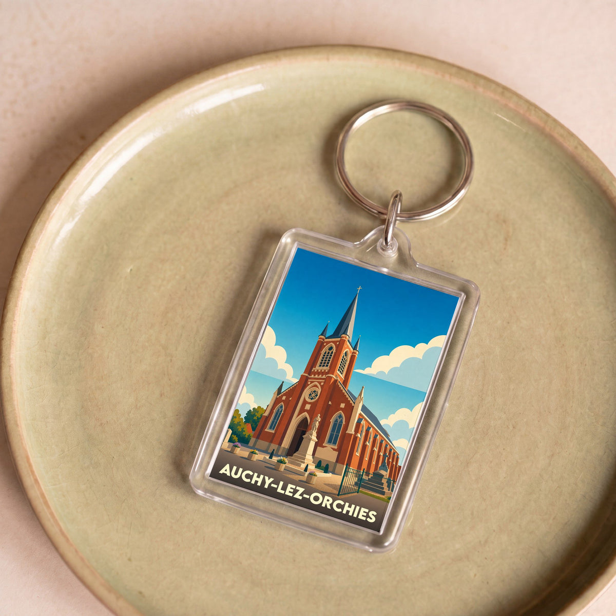 Porte-clés souvenir de la ville de Auchy-lez-Orchies avec une illustration stylisée de son église.