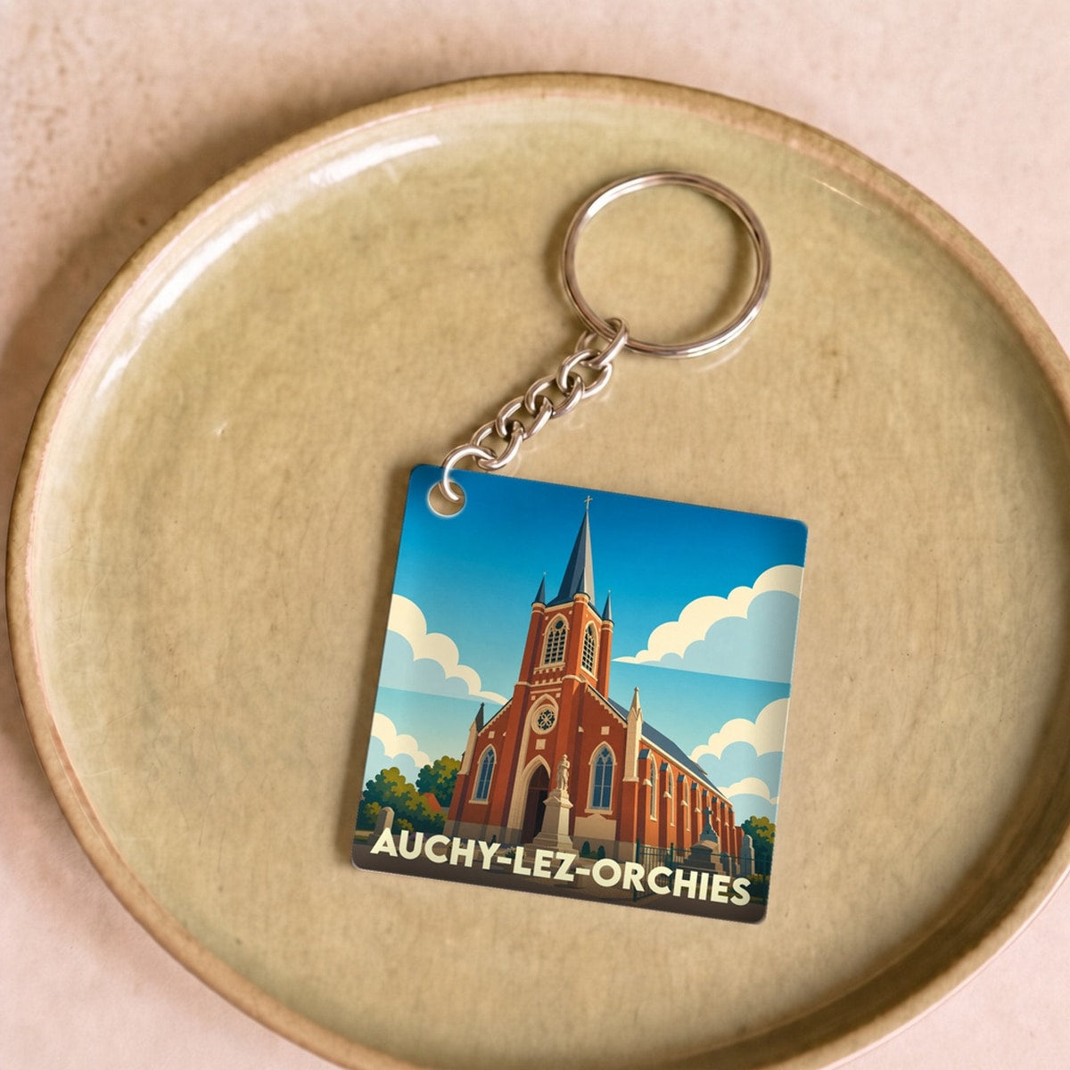 Porte-clés souvenir de la ville de Auchy-lez-Orchies avec une illustration stylisée de son église.