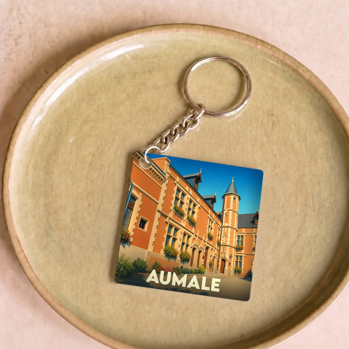 Porte-clés souvenir de la ville d'Aumale avec une illustration stylisée de son hôtel de ville.