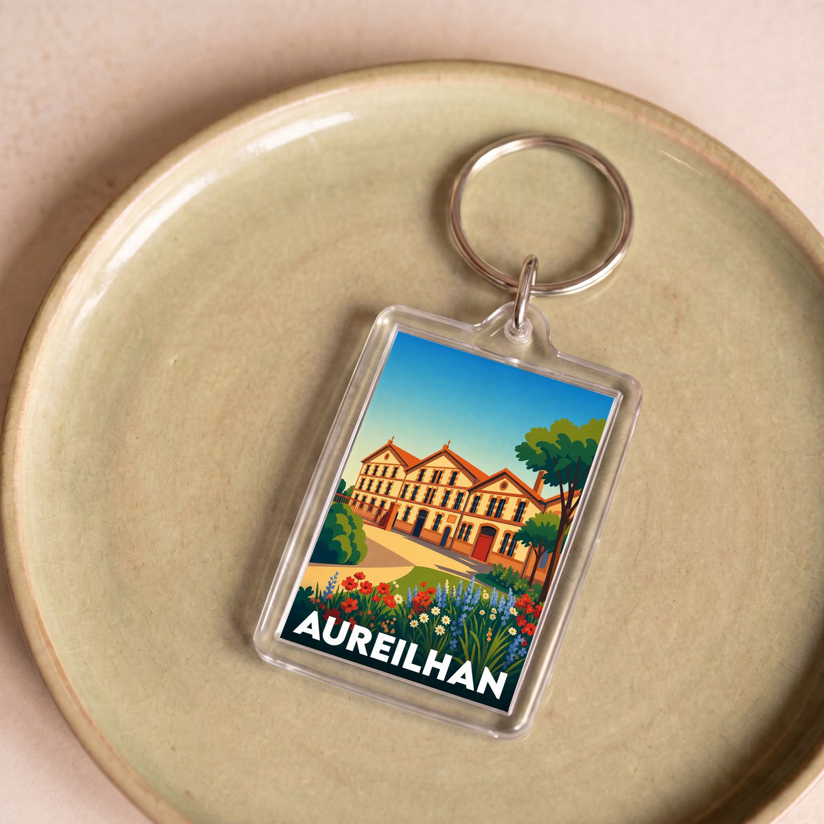 Porte-clés souvenir de la ville d'Aureilhan avec une illustration stylisée.