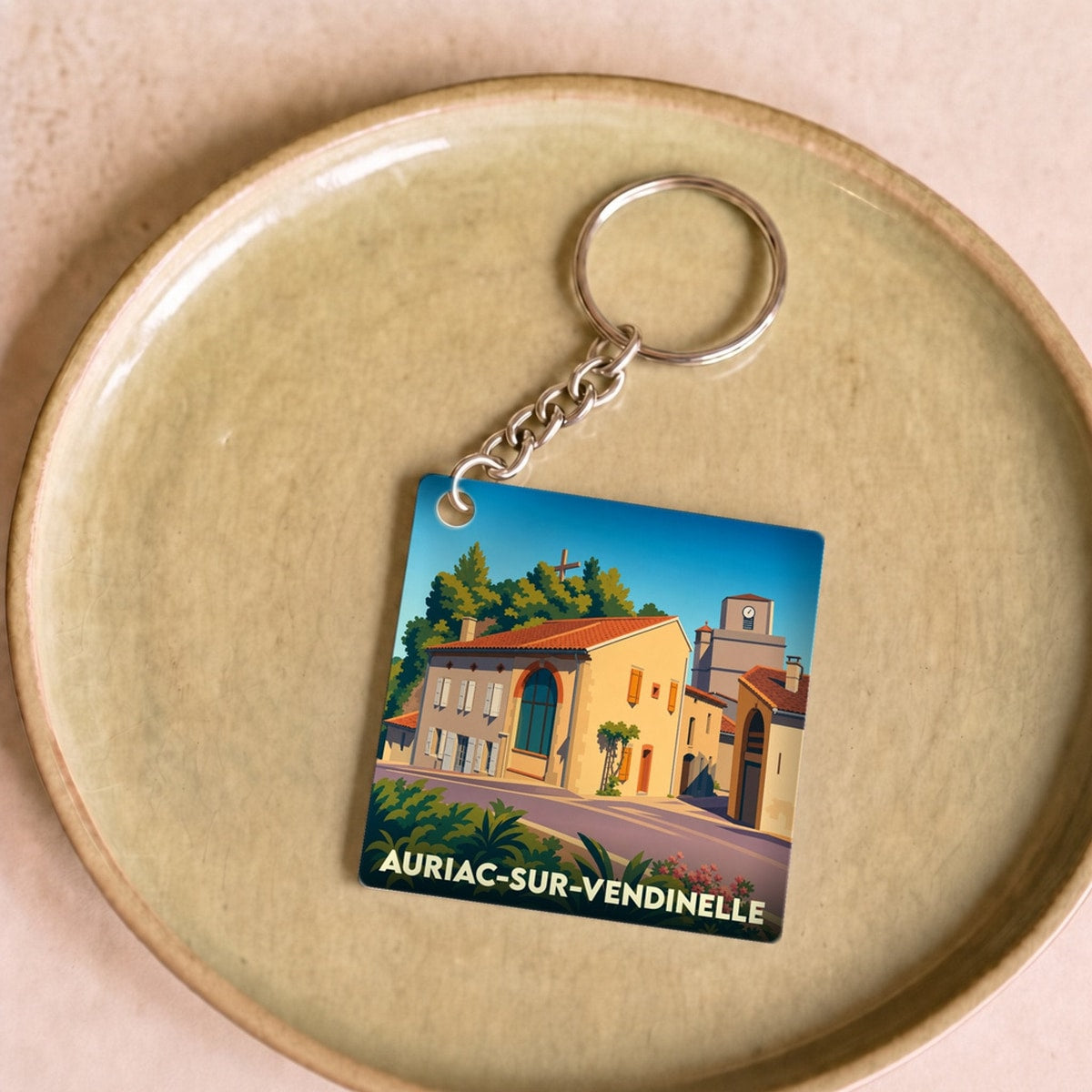 Porte-clés souvenir de la ville de Auriac-sur-Vendinelle avec une illustration stylisée.