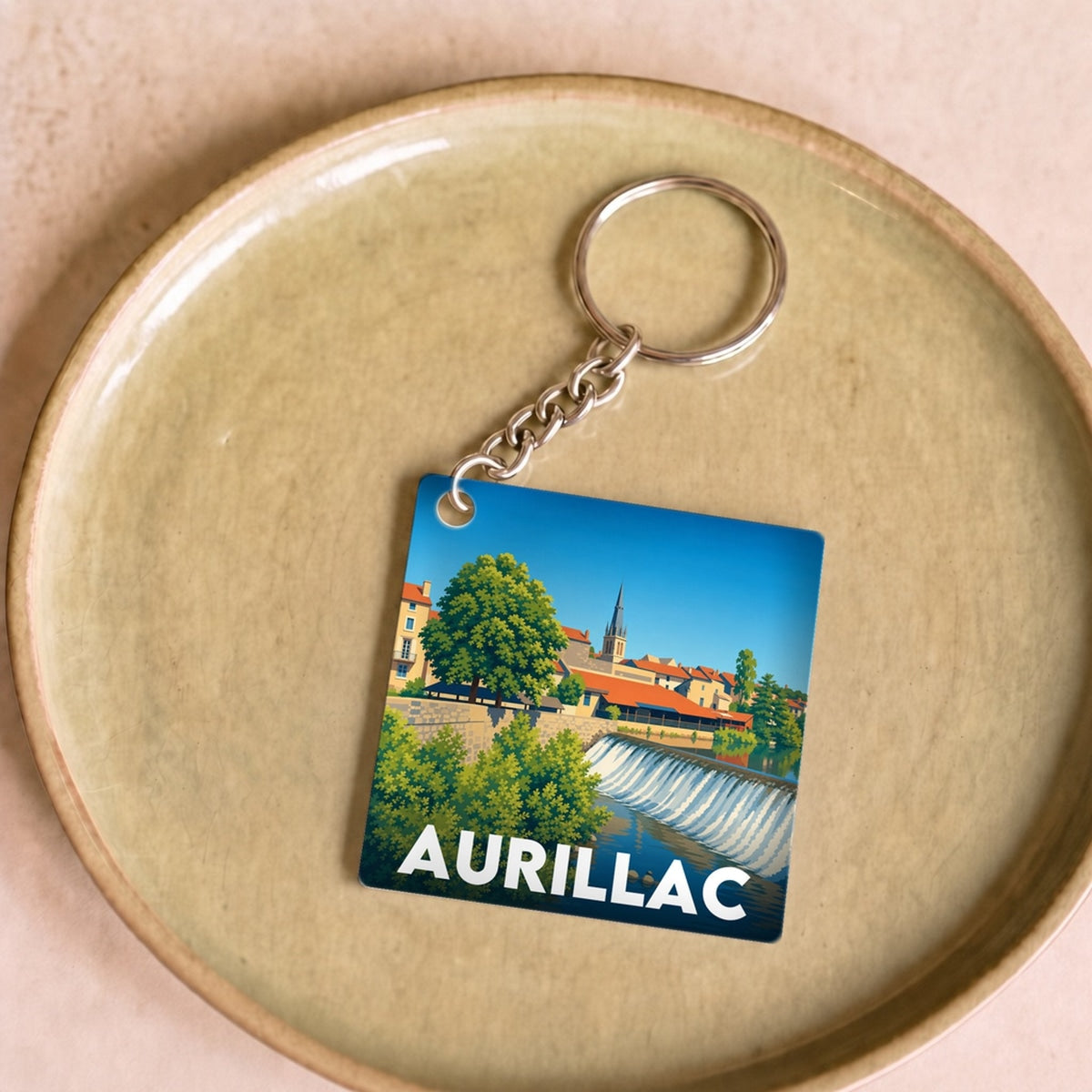 Porte-clés souvenir de la ville d'Aurillac avec une illustration stylisée.