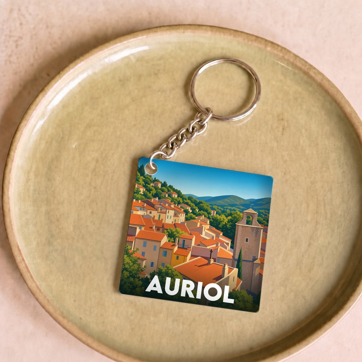 Porte-clés souvenir de la ville d'Auriol avec une illustration stylisée.