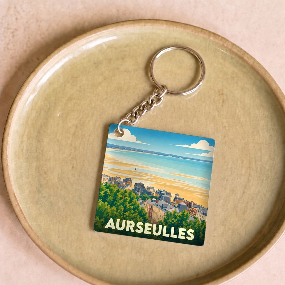 Porte-clés souvenir de la ville d'Aurseulles avec une illustration stylisée du littoral.
