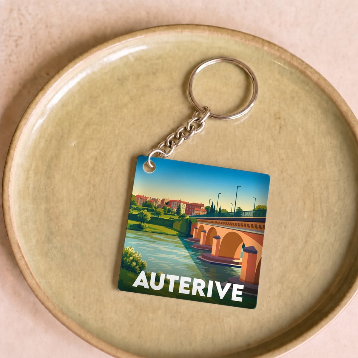 Porte-clés souvenir de la ville de Auterive avec une illustration stylisée de son pont.
