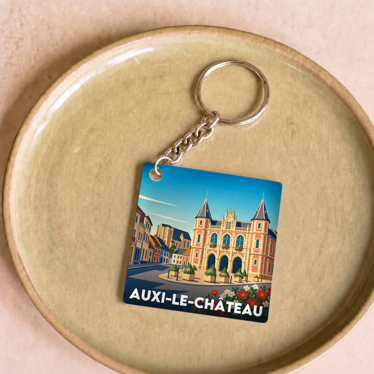 Porte-clés souvenir de la ville d'Auxi-le-Château avec une illustration stylisée de son architecture.