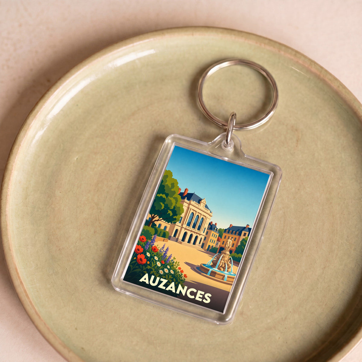 Porte-clés souvenir de la ville d'Auzances avec une illustration stylisée.