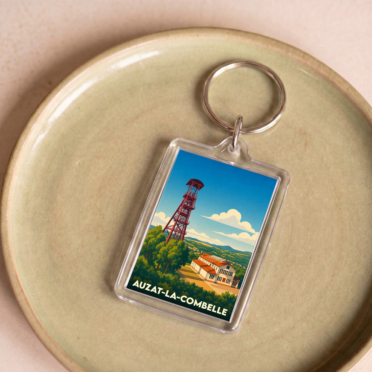 Porte-clés souvenir de la ville d’Auzat-la-Combelle avec une illustration stylisée de son chevalement minier.