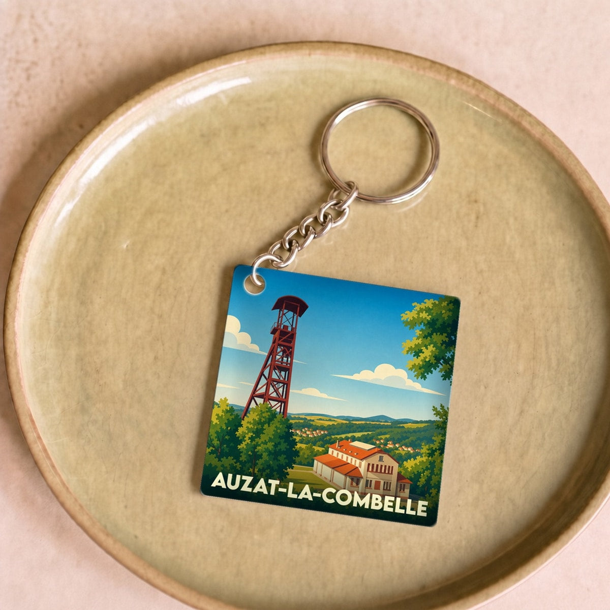 Porte-clés souvenir de la ville d’Auzat-la-Combelle avec une illustration stylisée de son chevalement minier.