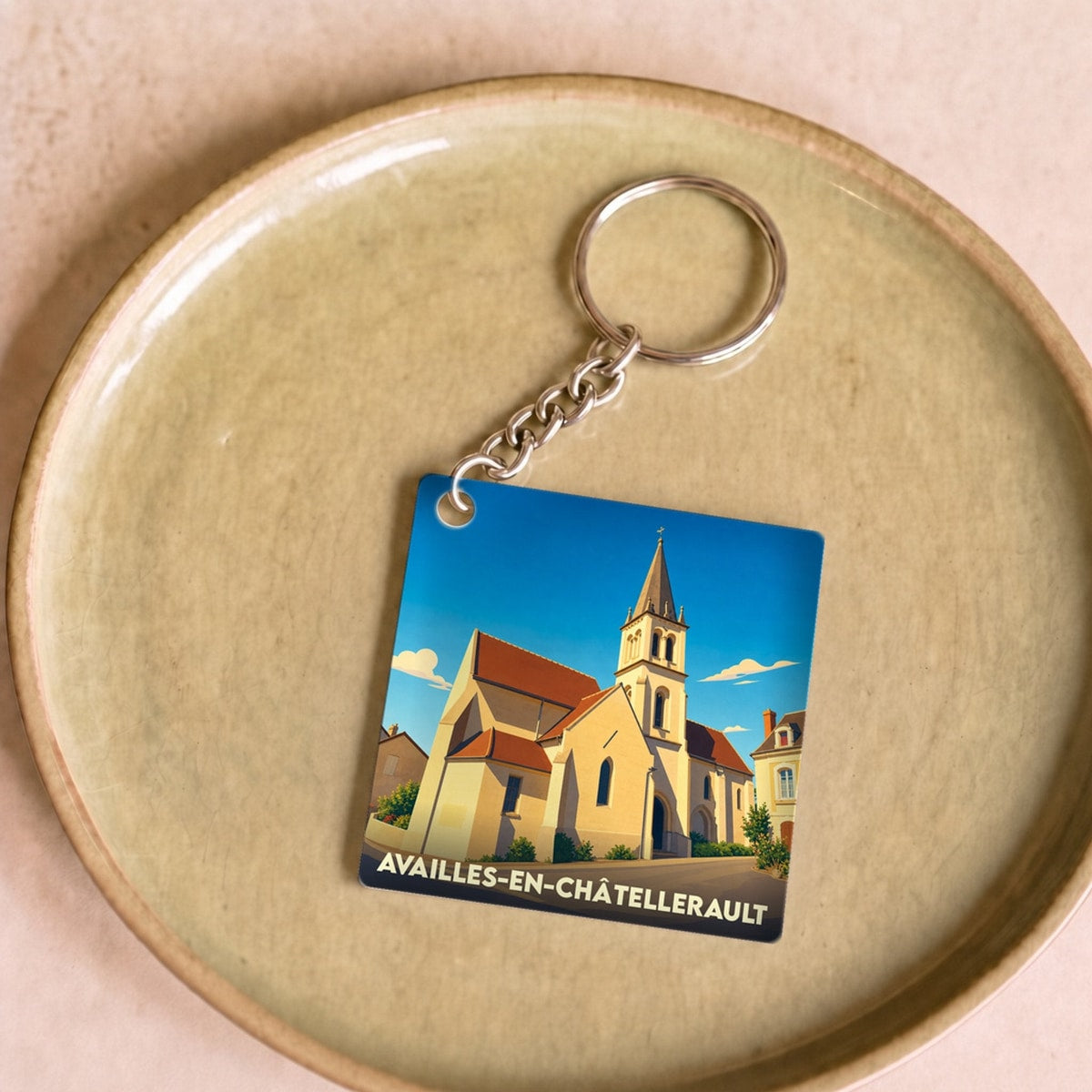 Porte-clés souvenir de la ville de Availles-en-Châtellerault avec une illustration stylisée de son église.