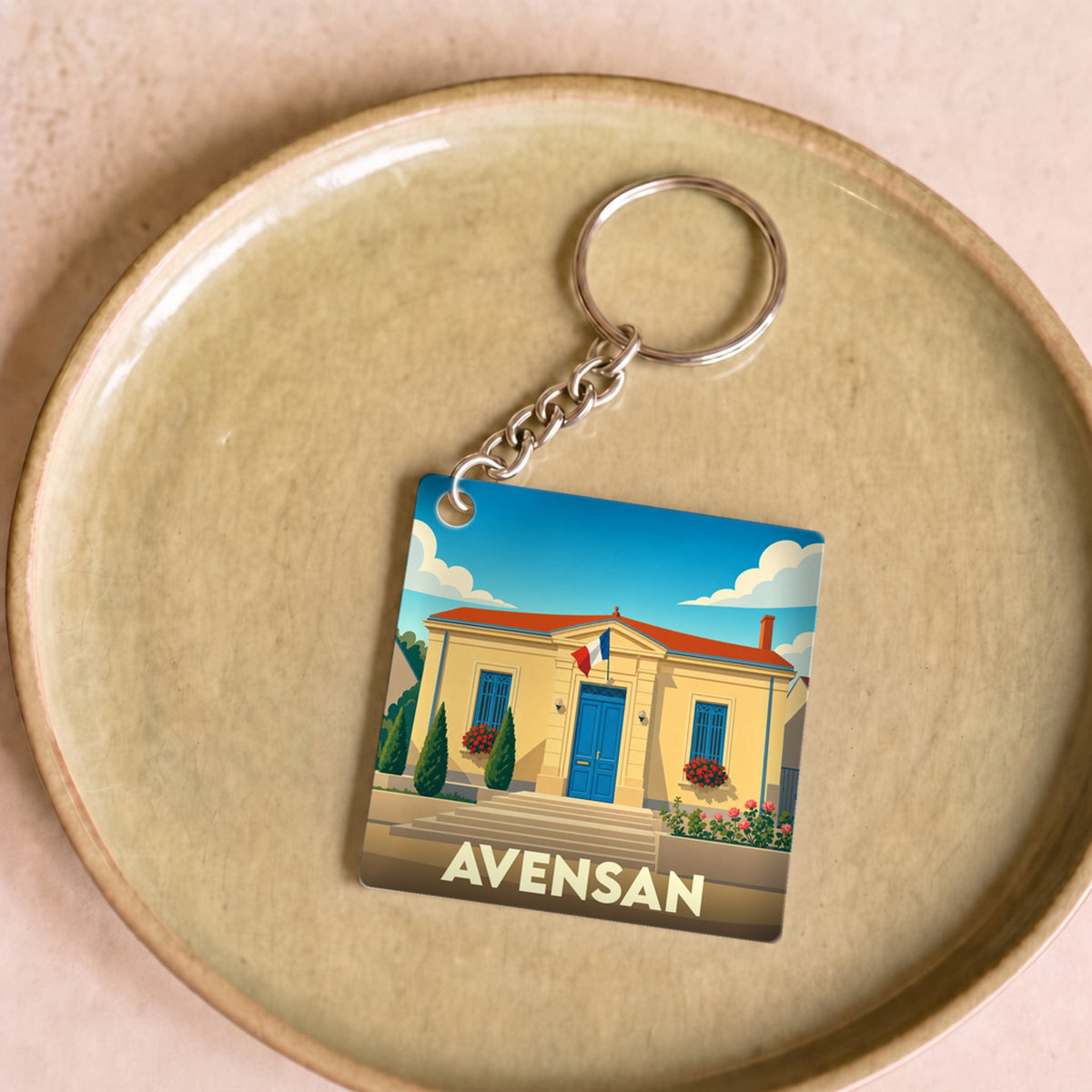 Porte-clés souvenir de la ville de Avensan avec une illustration stylisée.