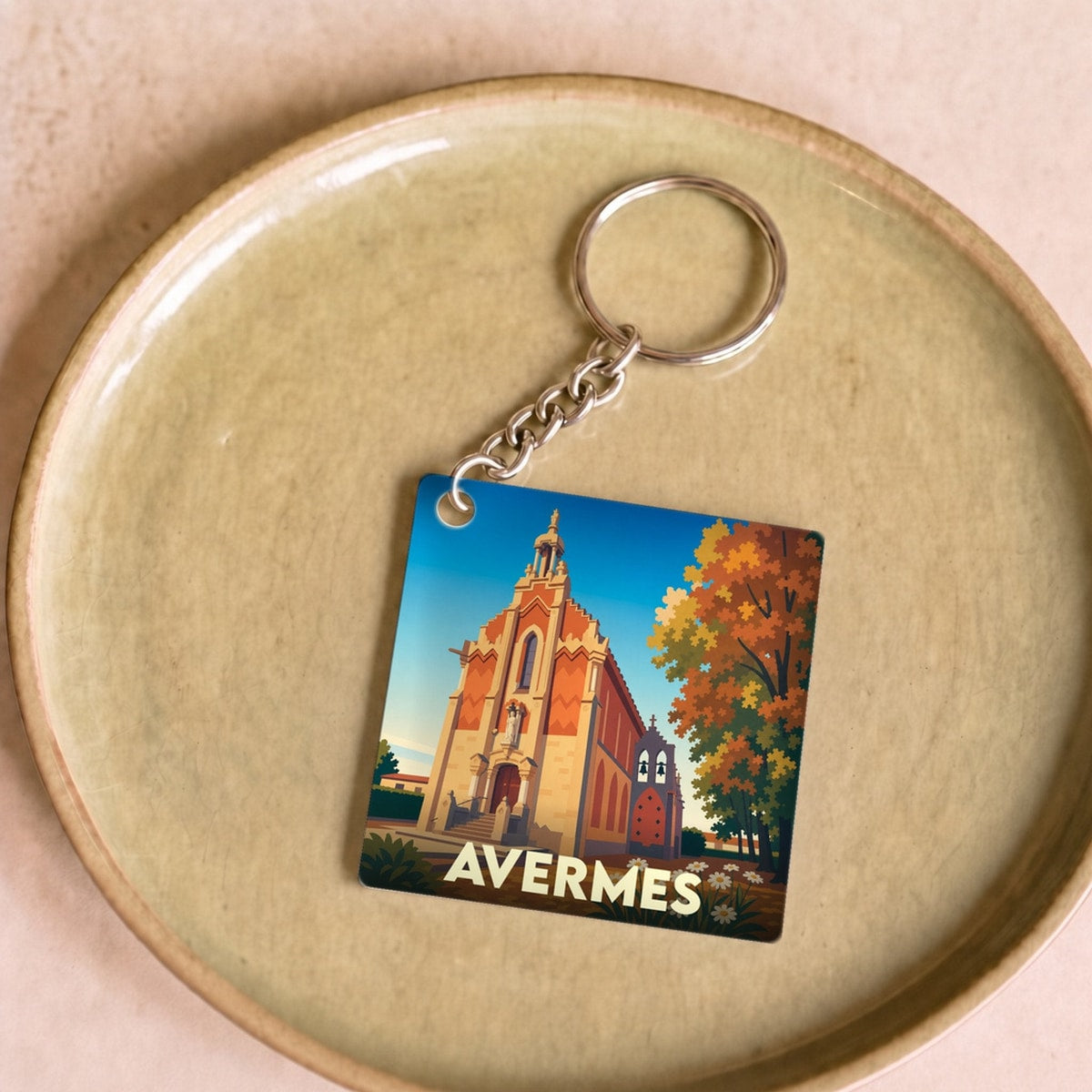 Porte-clés souvenir de la ville d'Avermes avec une illustration stylisée d'une église locale.