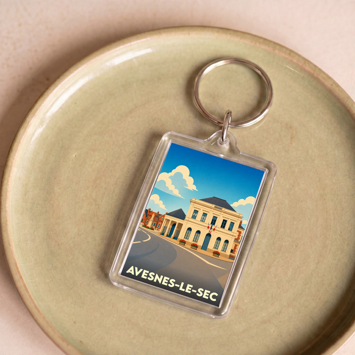 Porte-clés souvenir de la ville d'Avesnes-le-Sec avec une illustration stylisée de sa mairie.
