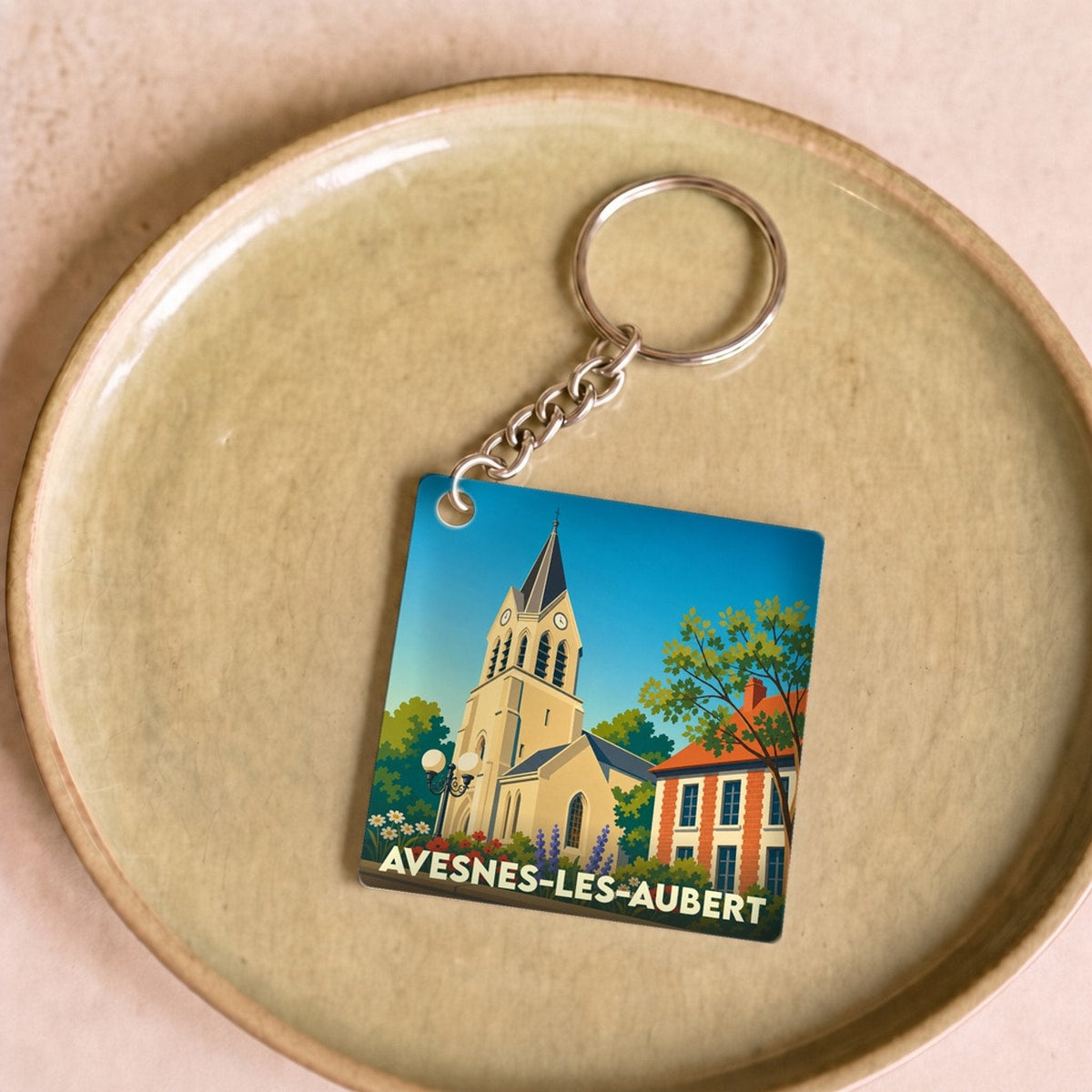 Porte-clés souvenir de la ville d'Avesnes-les-Aubert avec une illustration stylisée de son église.