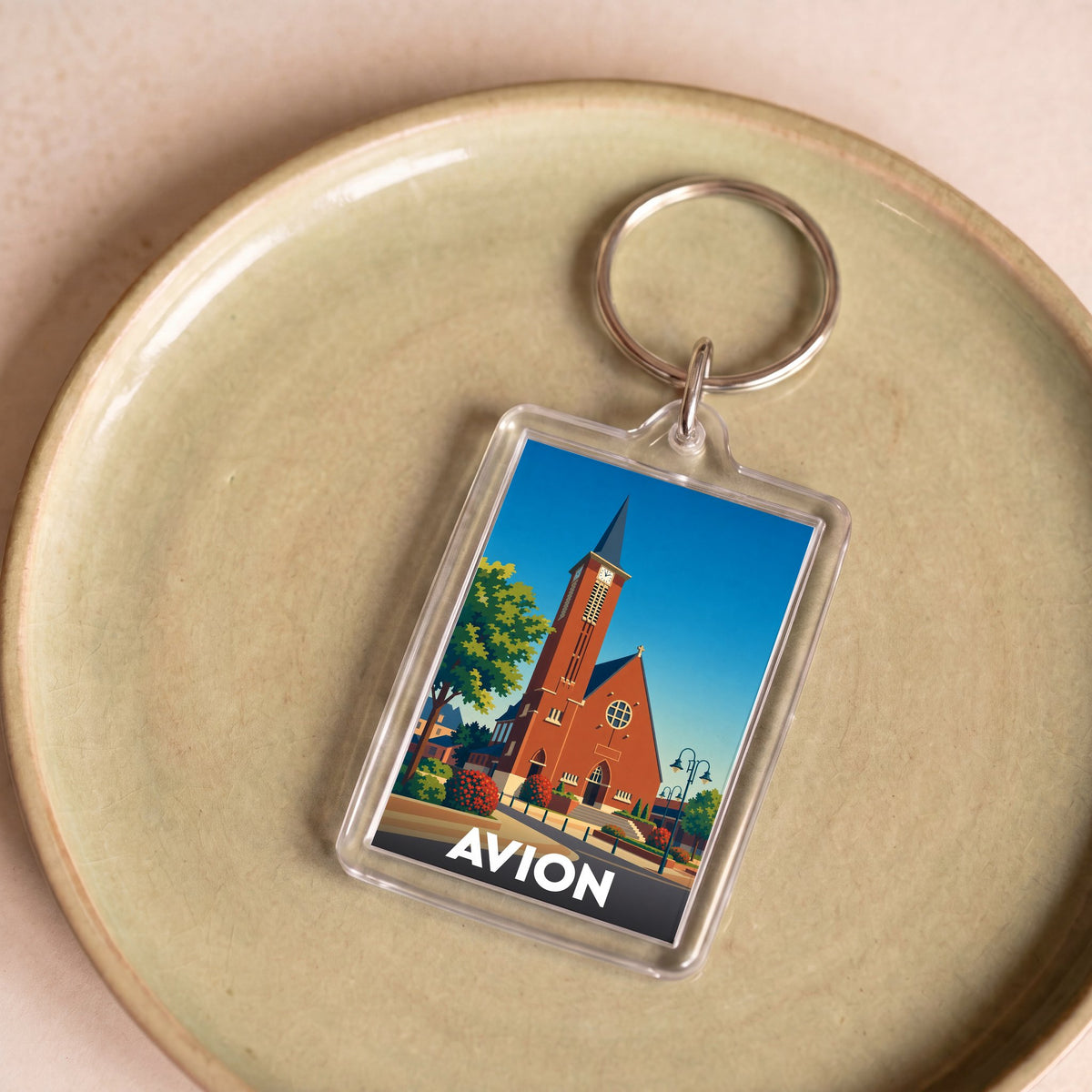 Porte-clés souvenir de la ville d'Avion avec une illustration stylisée.