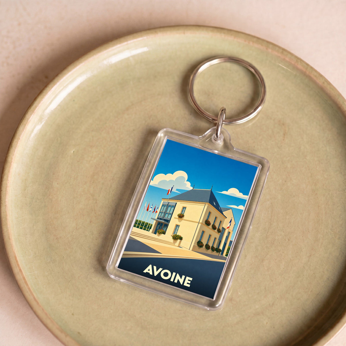 Porte-clés souvenir de la ville d'Avoine avec une illustration stylisée de son hôtel de ville.