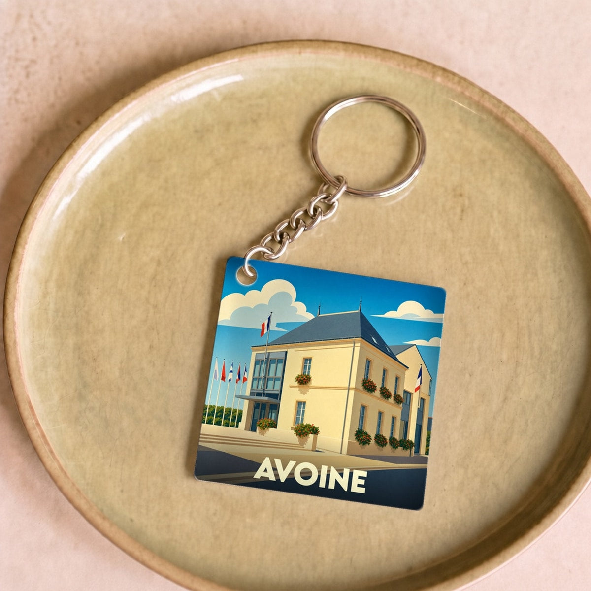 Porte-clés souvenir de la ville d'Avoine avec une illustration stylisée de son hôtel de ville.